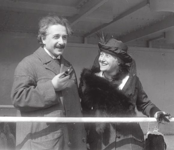 Эйнштейн с трубкой. Справа — его жена Эльза («Википедия»)